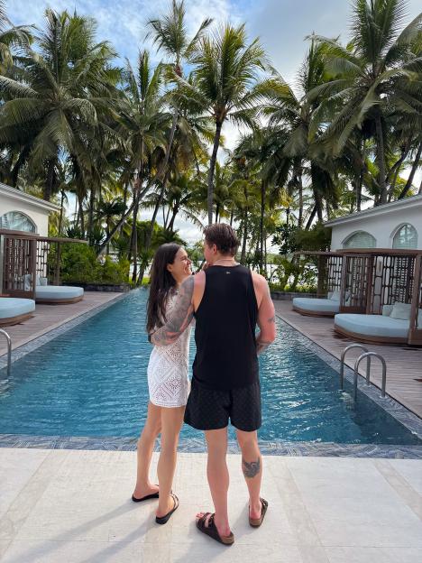 Holly Ramsay and Adam Peaty honeymooning by a pool with palm trees at One & Only Le Saint Geran Mauritius.