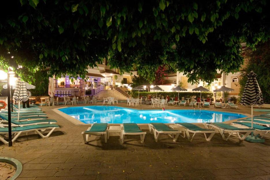 A hotel swimming pool and patio area at night.