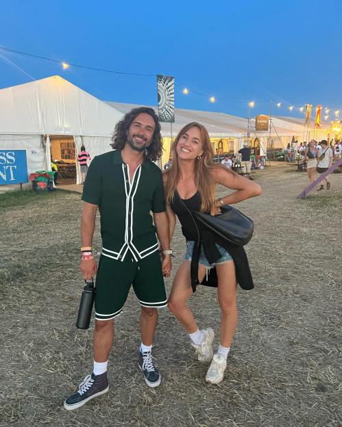Joe Wicks and his wife Rosie smiling at a festival.