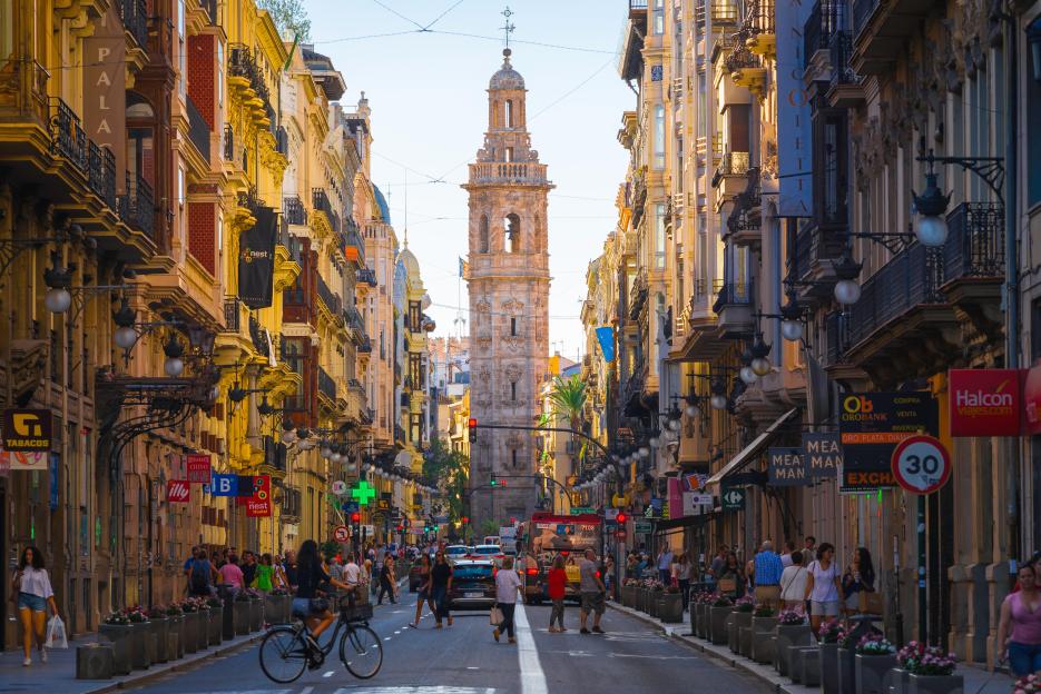 City view along the Calle de la Paz towards the baroque tower of the Santa Catalina church in the historic center of Valencia, Spain.
