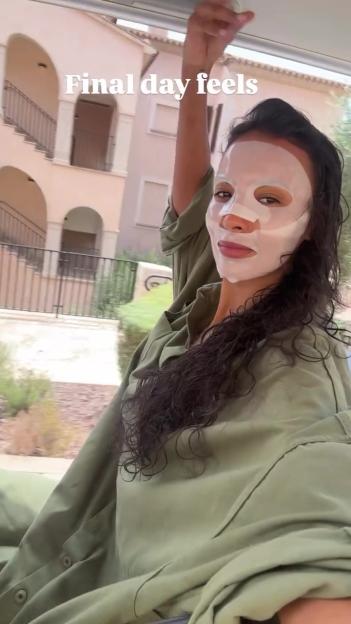 Maya Jama wearing a face mask in a car.