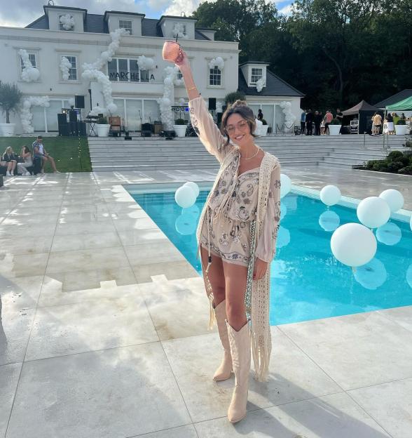 A woman holds a drink at the Marchella summer party.