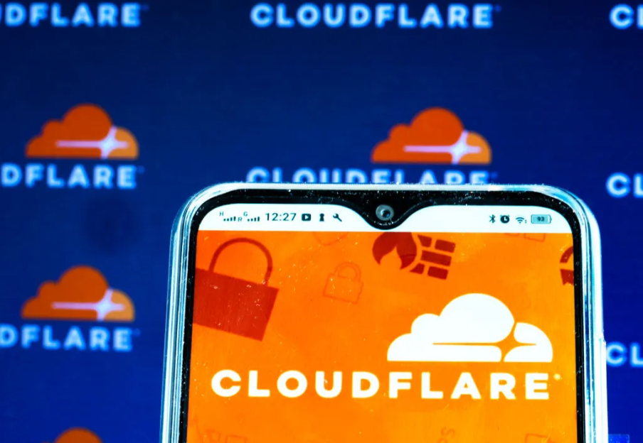 A smartphone displaying the Cloudflare logo and wordmark against a background with repeated Cloudflare logos.