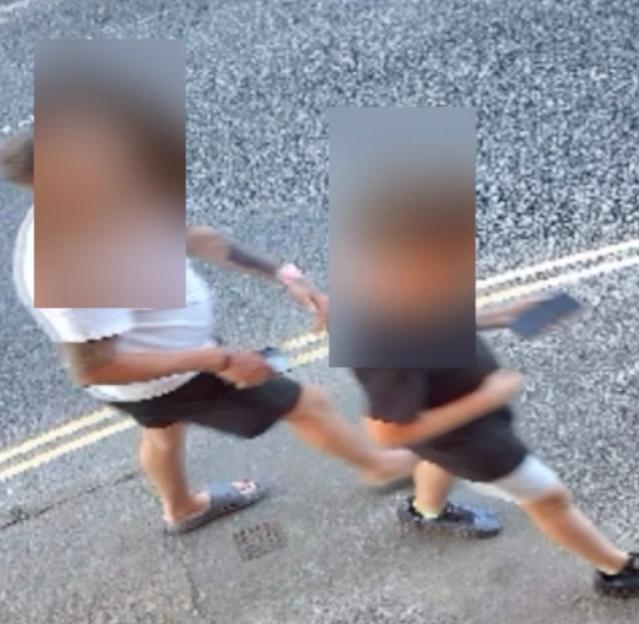 A father in sunglasses and his son with a tablet walk away from a restaurant without paying.
