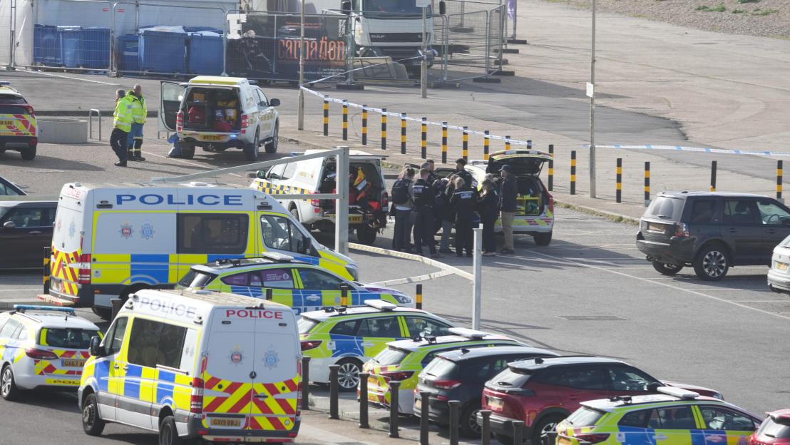 Police and Coastguard vehicles with personnel at the scene of a sea search.