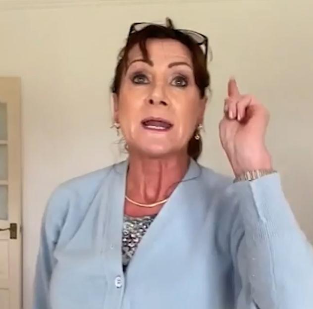 Pamela Gwinnett points upwards with her right hand.