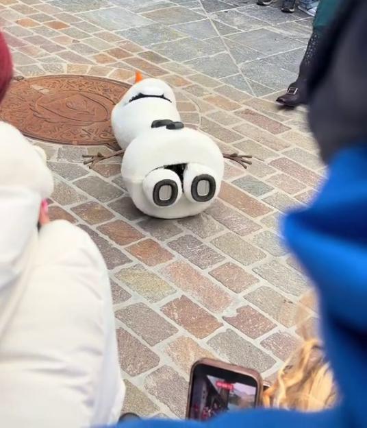 Olaf robot malfunctioning and falling over in front of park visitors.