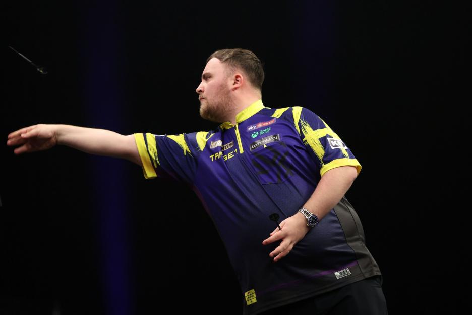 A male darts player in a blue and yellow shirt throws a dart during PDC Premier League Darts, Night 7.