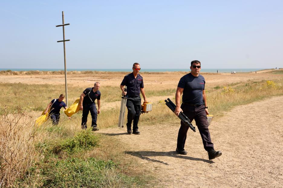 Kent fire service personnel removing equipment from a murder scene at Warden Bay Beach.