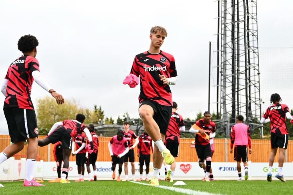 Soccer players warming up on a field.