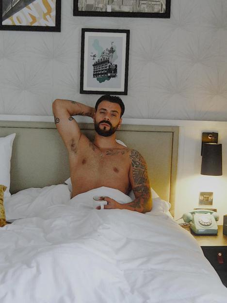 Davide Sanclimenti lying in bed shirtless.
