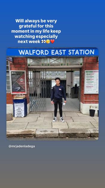 Actor Jaden Ladega standing in front of the Walford East Station sign.