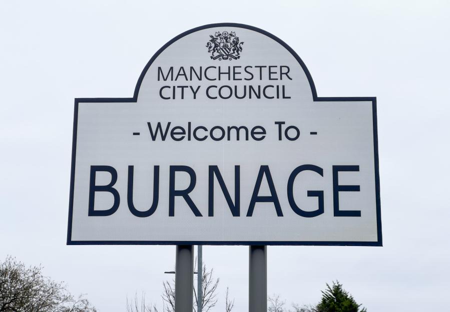 Sign welcoming visitors to Burnage, Manchester, with "Manchester City Council" and a crest above.