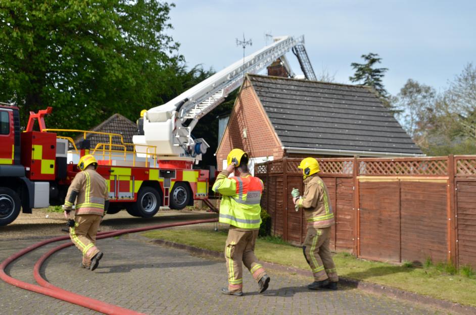 Firefighters at a house in Spalding with an extended ladder from a fire truck.