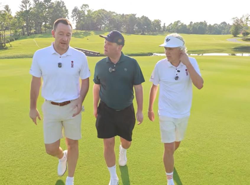 Three men walking on a golf course.