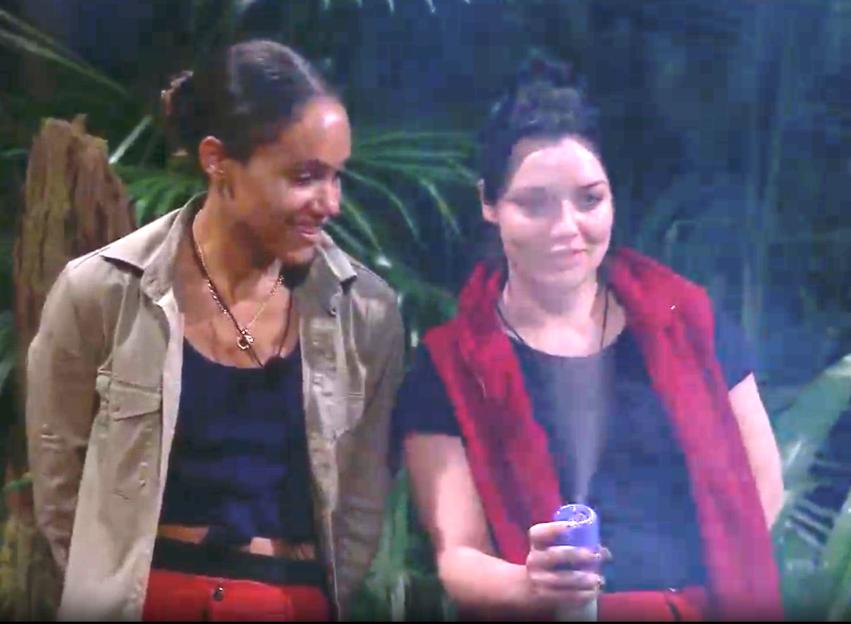 Two women in jungle attire, one holding a purple spray bottle.