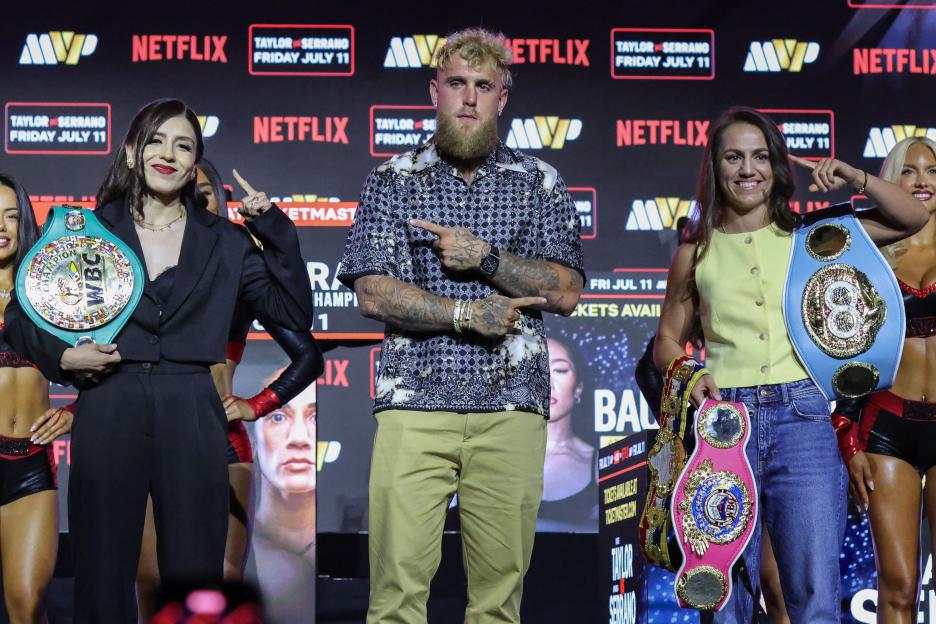 Amanda Serrano and Jake Paul stand in the ring before her unified World Featherweight Championship bout.