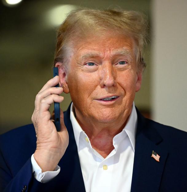 Donald Trump talking on a phone in the McLaren garage at the F1 Grand Prix of Miami.