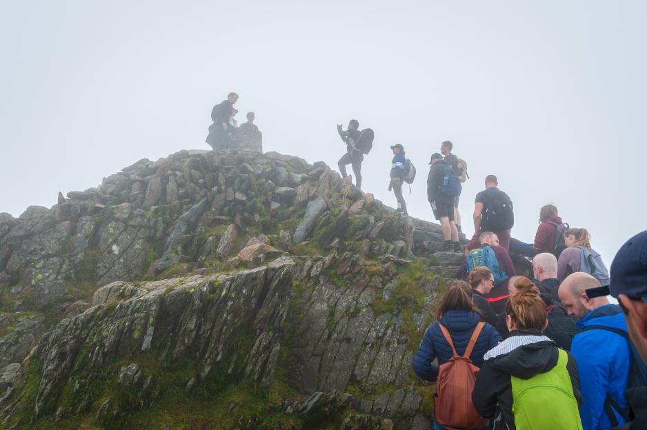 Hikers queuing in the fog on Mount Snowdon, Wales, UK.