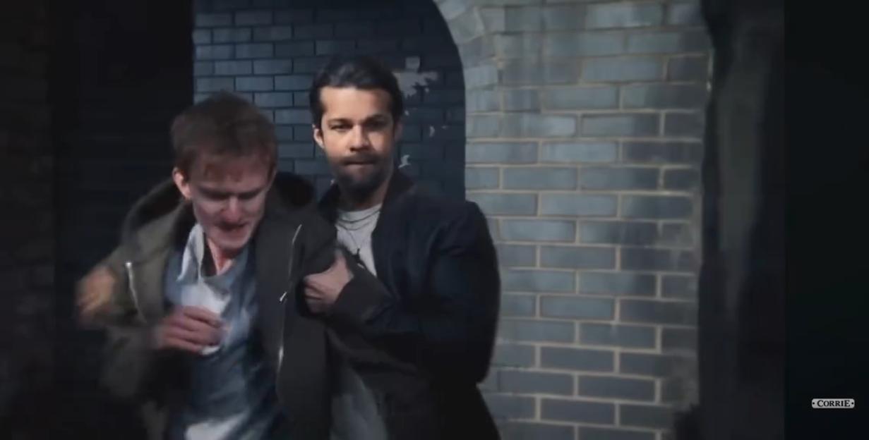 Two men, one holding the other's arm, emerging from a dark tunnel.