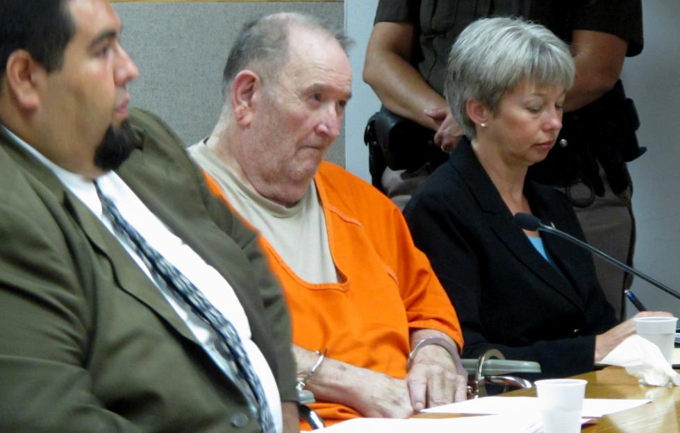 Edward W. Edwards, handcuffed in a wheelchair, sits between his public defenders Jeffrey De La Rosa and Elizabeth Svehlek during his sentencing.