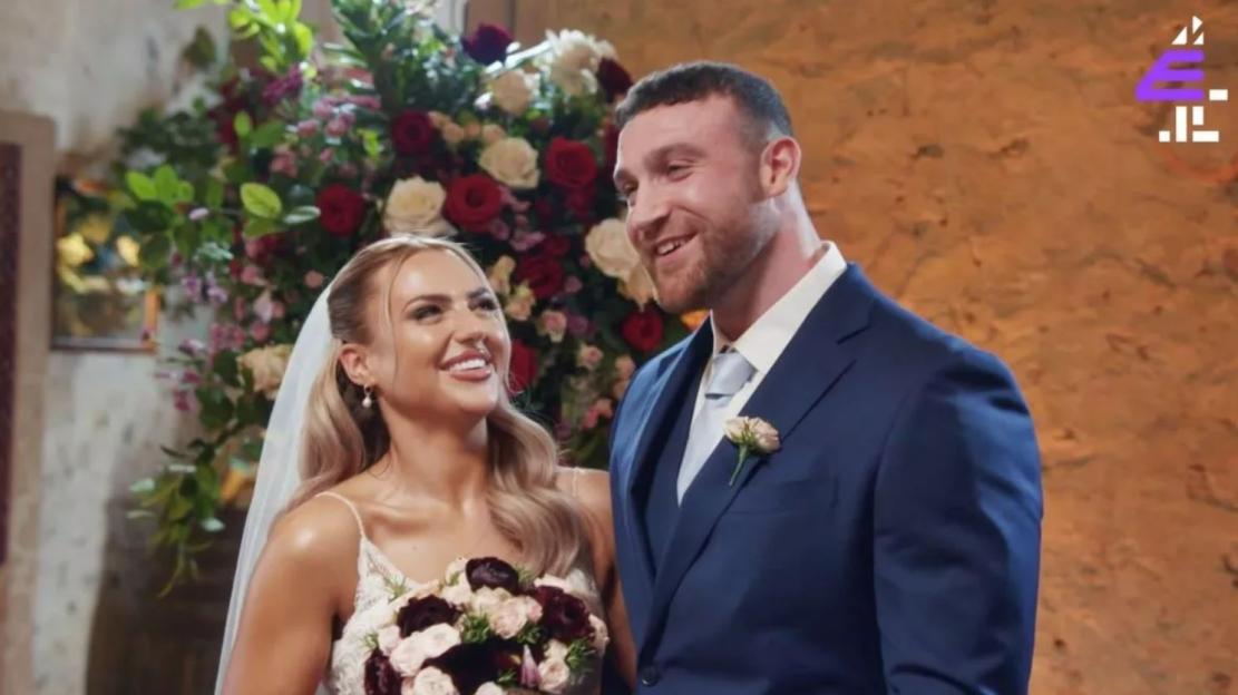Adrienne Naylor and a man in a blue suit at their wedding.