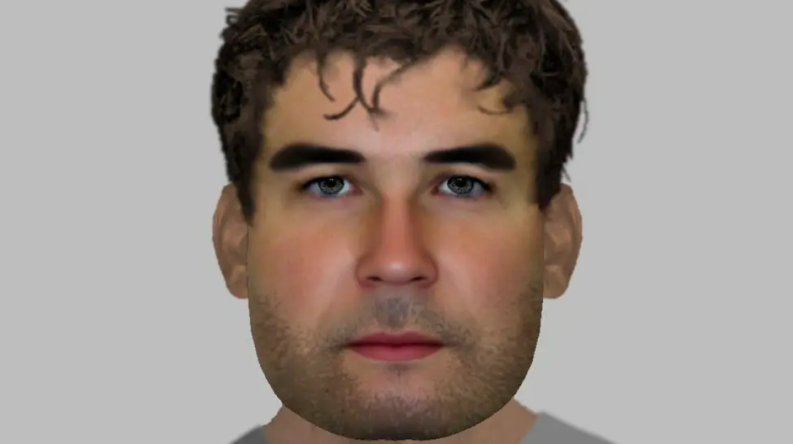 Illustration of a man's face with brown curly hair, dark eyebrows, light eyes, and stubble.