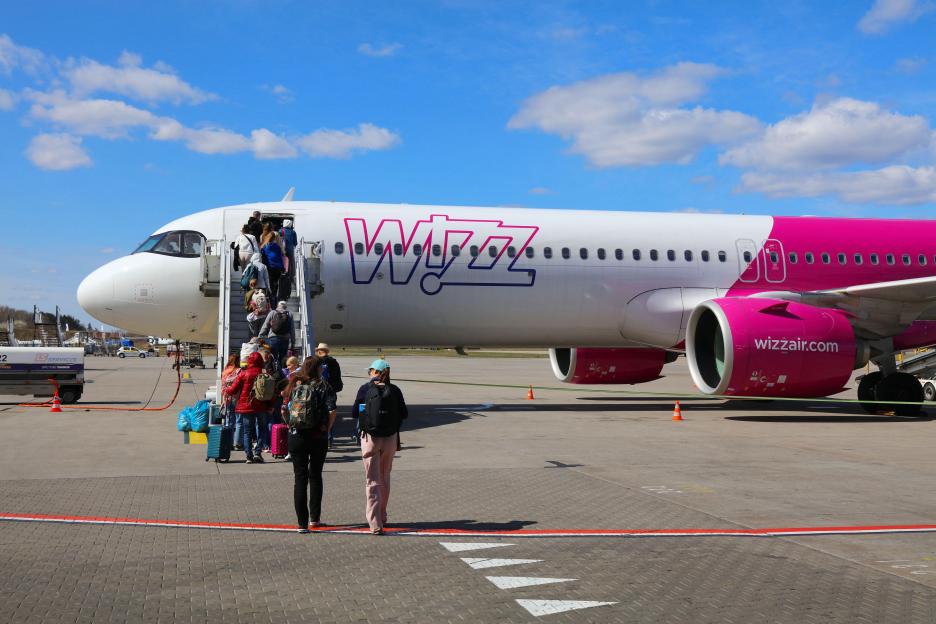 People boarding a Wizzair Airbus A321 neo aircraft via stairs at Katowice International Airport.