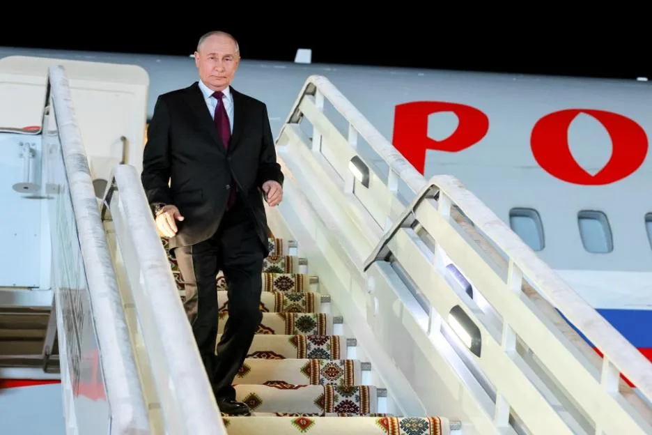 Russian President Vladimir Putin descends the stairs of an airplane after arriving in Turkmenistan.
