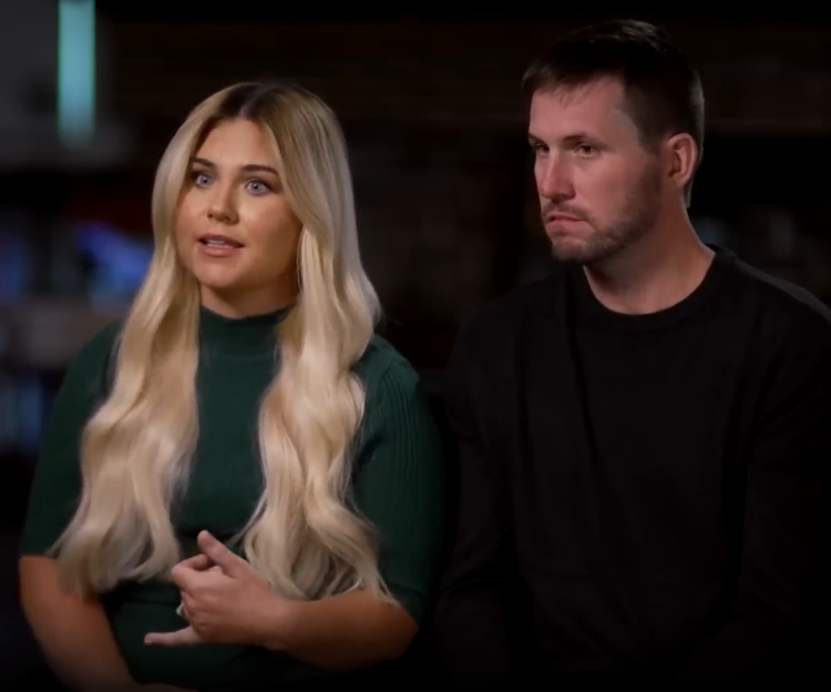 A woman with long blonde hair and a man with short brown hair sitting side-by-side.