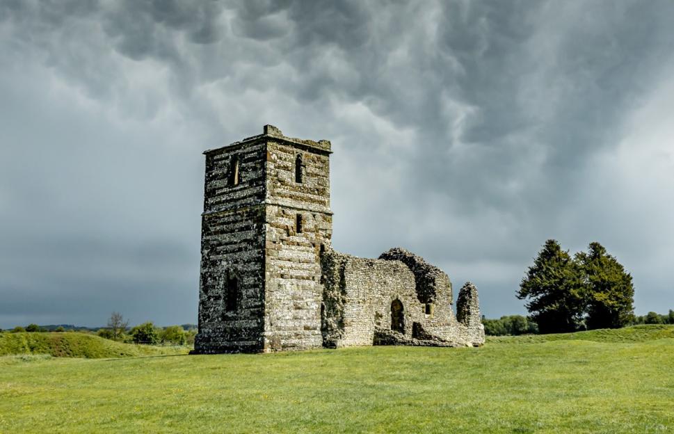 Knowlton Church ruins under dark, dramatic mammatus clouds.