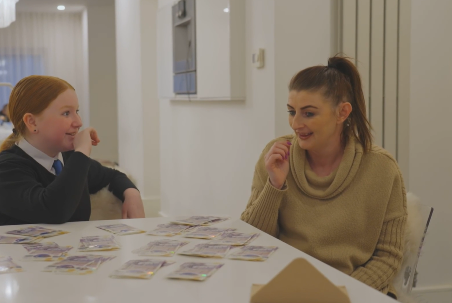 A young woman and a girl sitting at a table with money spread out in front of them, from the show "Rich House, Poor House."