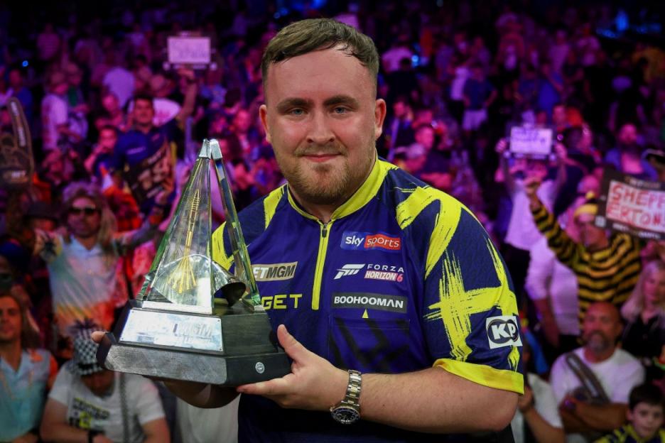 Luke Littler lifts the BetMGM Premier League Darts Final trophy.
