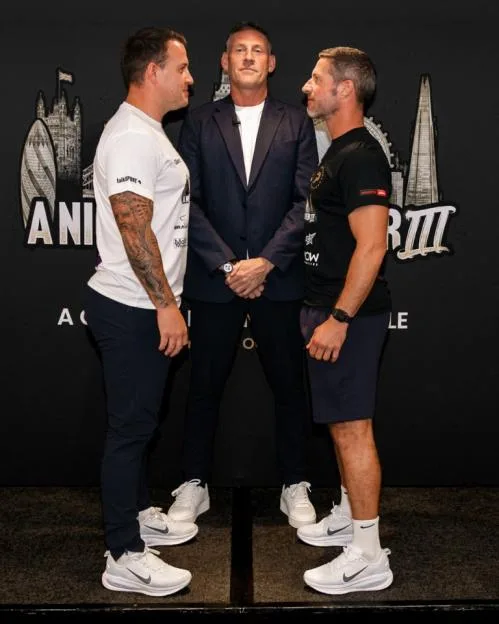 Two men face-off with a referee standing between them.