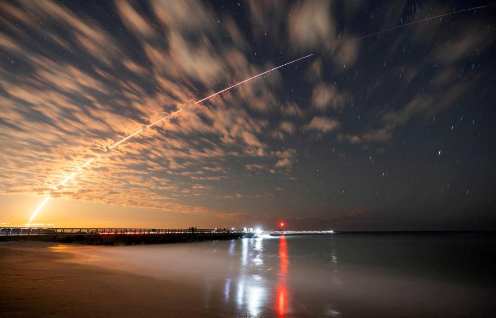 Long exposure of a SpaceX Falcon 9 rocket launching from Cape Canaveral over Sebastian Inlet.
