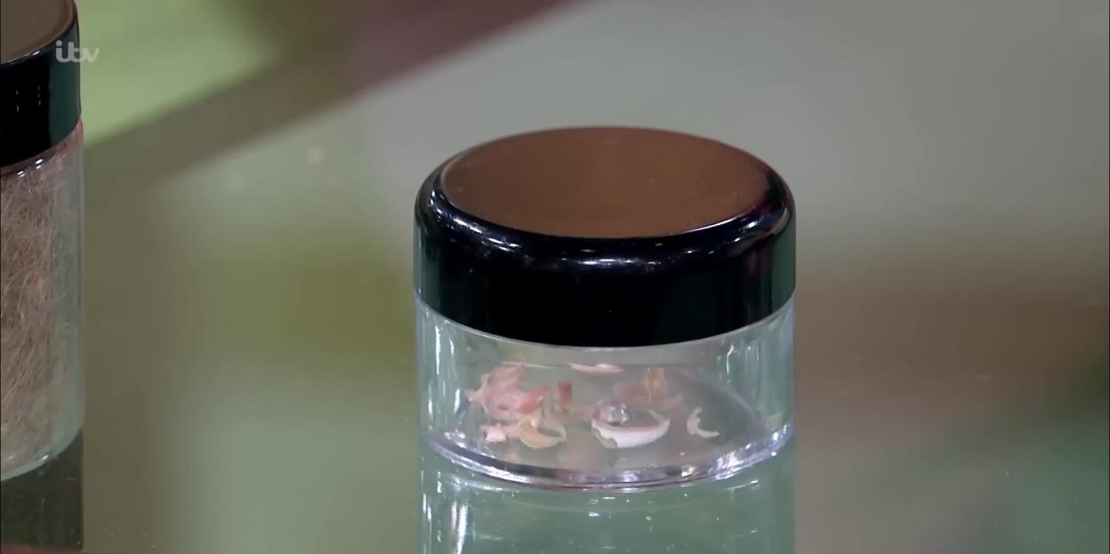 Small plastic jar filled with toenail clippings.