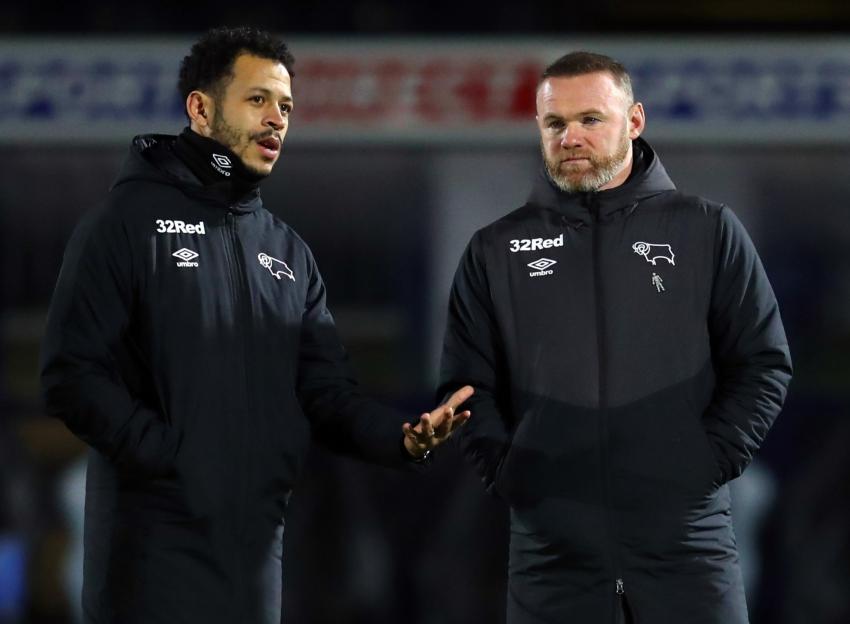 Wayne Rooney and Liam Rosenior on the field in team jackets.