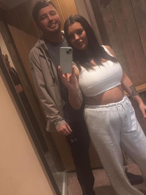 A couple taking a mirror selfie.