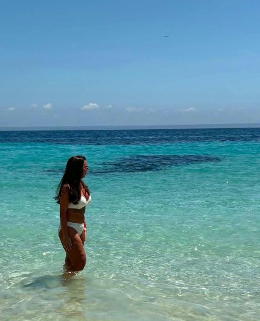 Katie Bailey standing in clear blue water at the beach.