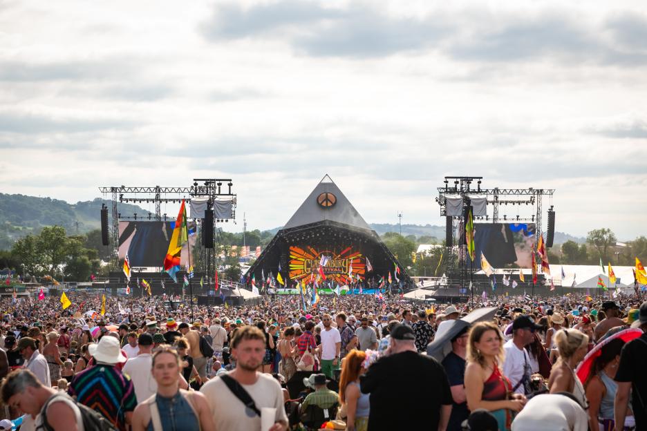Crowd of people gathered in front of the Pyramid stage at Glastonbury Festival.
