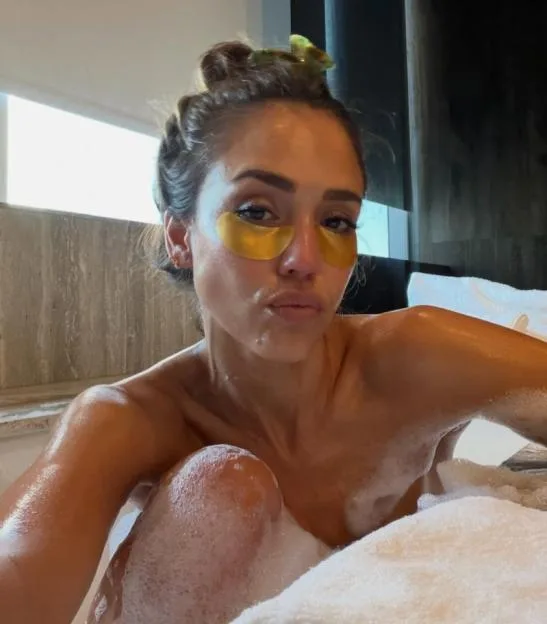 Jessica Alba in a bubble bath wearing under-eye patches.