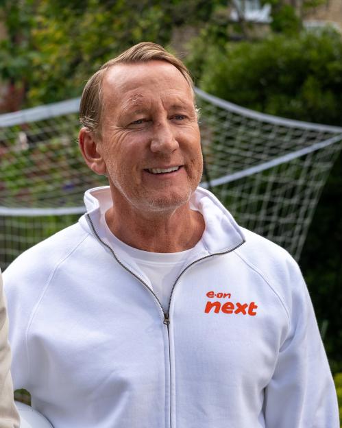 Man in a white track jacket with "e.on next" logo.