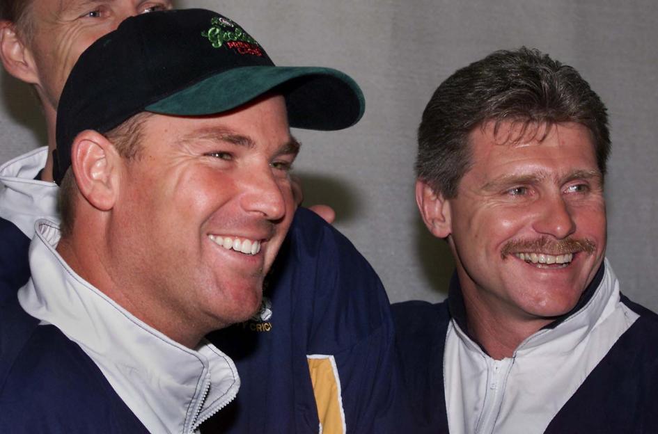 Australia's Shane Warne (L) and team captain Robin Smith (R) smiling.
