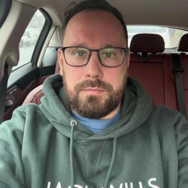 Krisstoffer Henshall wearing glasses and a hoodie in a car.