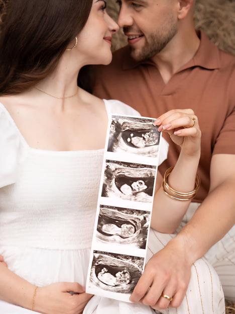 Emmerdale star Isabel Hodgins and her husband Adam Whitehead holding ultrasound photos.