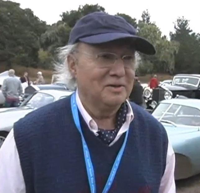 Classic car collector Hugh Taylor in a blue vest, white shirt, and a dark blue cap.