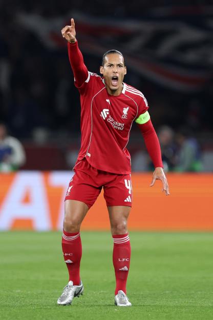 Virgil van Dijk of Liverpool FC in a red uniform, pointing upwards and shouting.