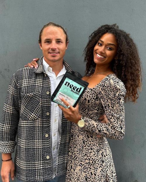 Natalie and Jack Visick, a couple, smiling and holding a "Need Beans" coffee package.