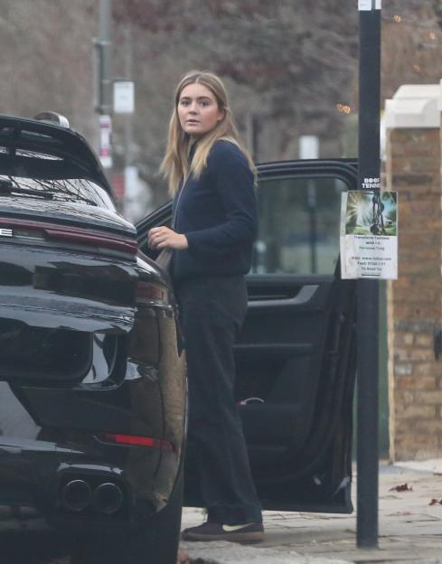 A woman stands next to an open car door outside Gordon Ramsay's London home.