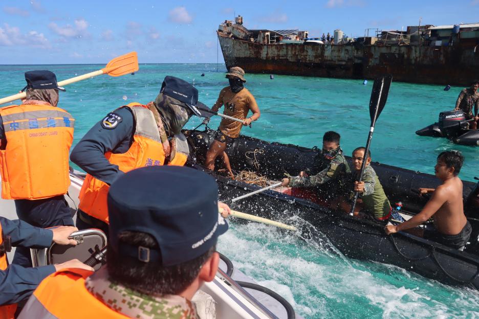Philippine Navy personnel and China Coast Guard personnel near a grounded Philippine warship at Second Thomas Shoal